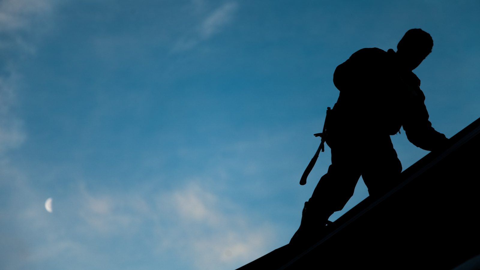 Roofer silhouetted on a rooftop at dusk