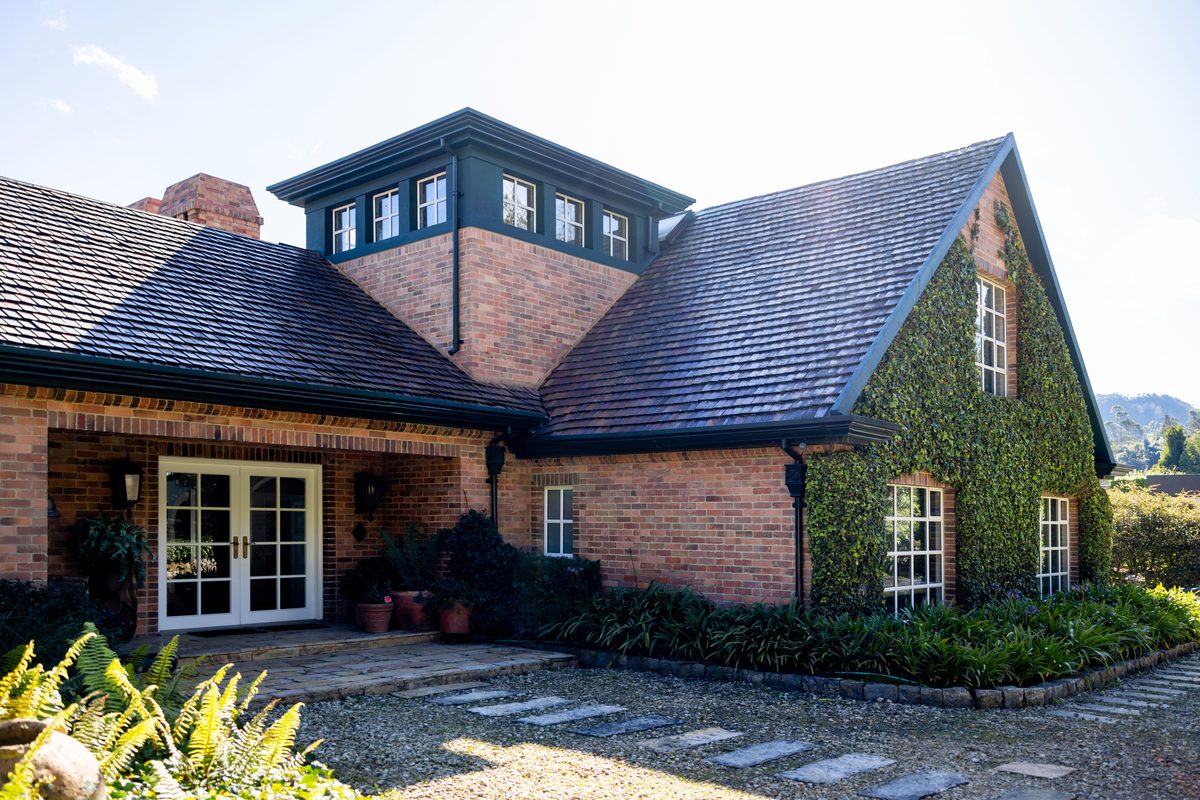 Finished dark shingle roof on a brick craftsman home